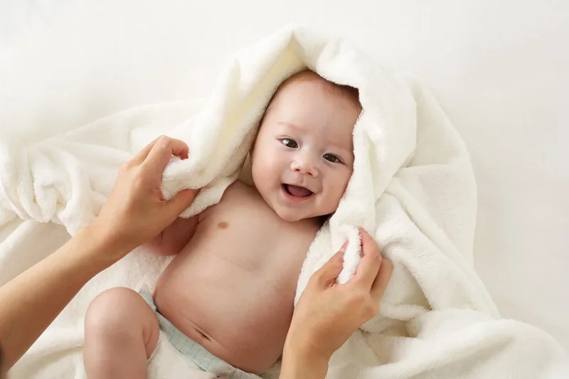 Smiling newborn wrapped in a towel